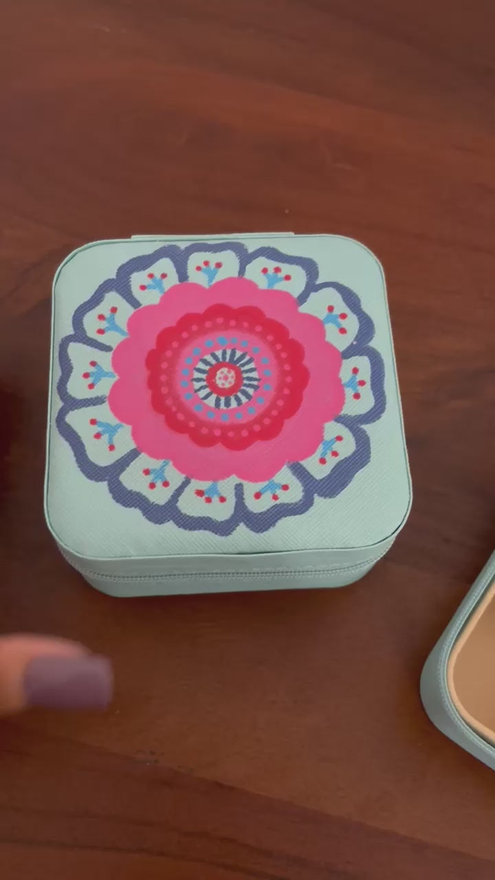 Blue floral jewellery box displayed on wooden and fabric background. kalavrit